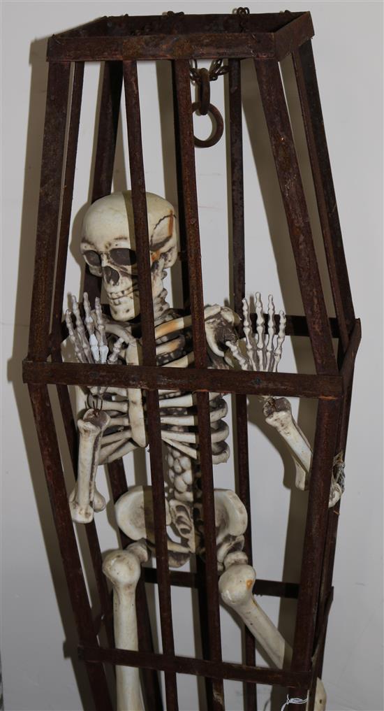 A composition miniature skeleton in coffin shaped cage, H.100cm